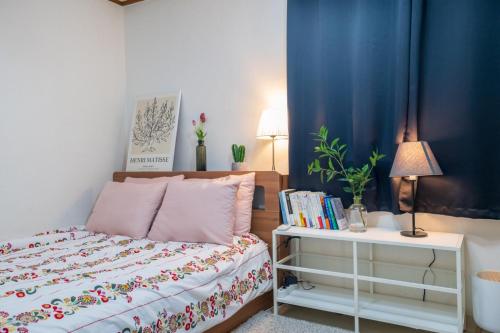ein Schlafzimmer mit einem Bett und einem Tisch mit Büchern in der Unterkunft Stay CarpeDiem Hannam in Seoul