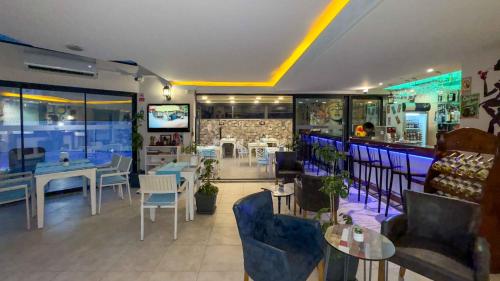 a restaurant with tables and chairs and a bar at La Bella Suit Otel in Kusadası