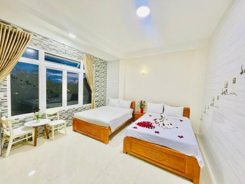 a bedroom with two beds and a window at Da Lat Ngoi Sao Viet in Da Lat