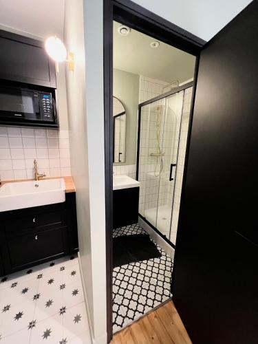 a bathroom with a shower and a sink and a mirror at Pere Lachaise Apartments in Paris