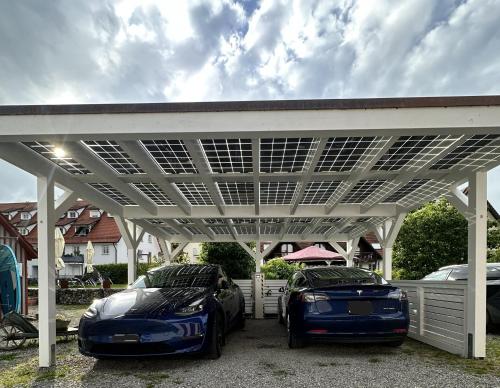 two luxury cars parked under a white pergola at SeeHotel Amtshof in Langenargen