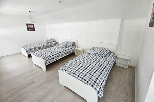 Duas camas num quarto com paredes brancas em Work & Stay Apartments mit Garten 