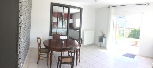 une salle à manger avec une table et des chaises en bois dans l'établissement Maison dans un écrin de verdure, à Saint-Brieuc
