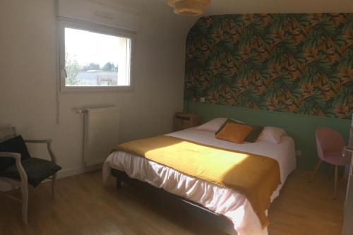 une chambre avec un lit et une fenêtre dans l'établissement Maison dans un écrin de verdure, à Saint-Brieuc