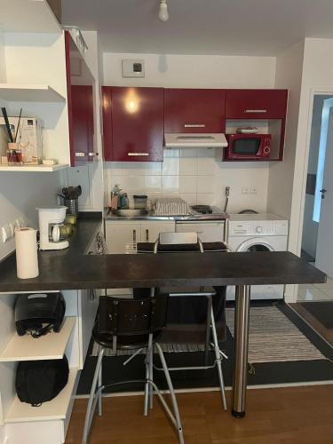 une cuisine avec des armoires rouges et un comptoir dans l'établissement Cardinet, à Paris