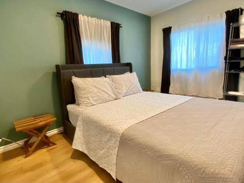 a bedroom with a bed with a white comforter and a window at Pasadena Old Town in Pasadena