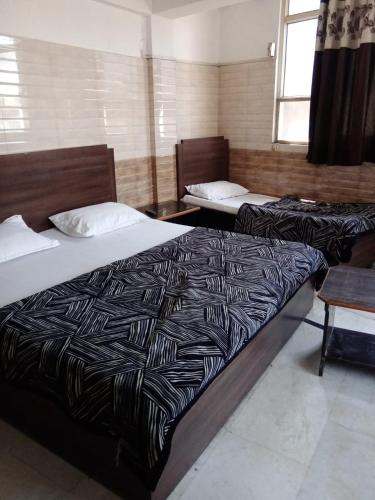 a room with two beds and a table and a bed sidx sidx sidx at hotel sunny international in Jammu