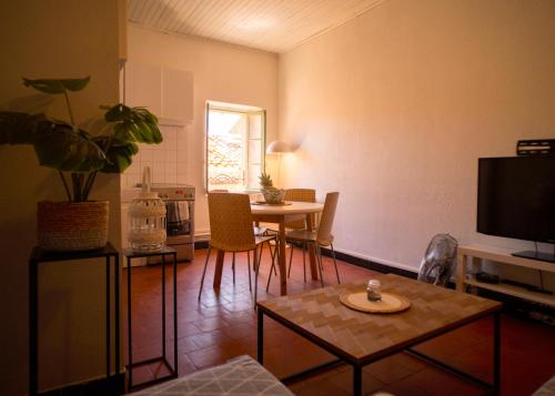 un salon avec une table et une télévision dans l'établissement Confortable 3 pièces au centre de VIAS, à Vias