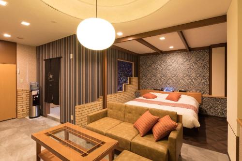 にある弥富ホテルヌク全室天然温泉のベッドルーム(ベッド1台、ソファ付)