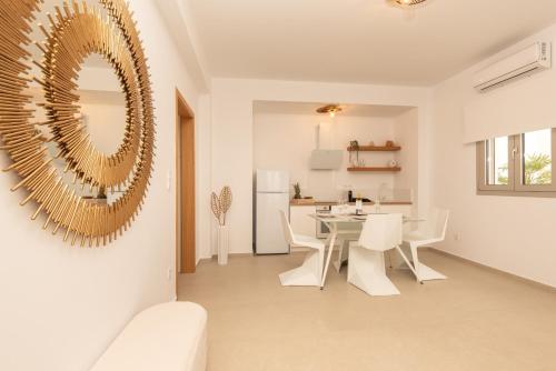 a dining room with a table and chairs and a mirror at Mia Anasa - Luxury Suites in Masouri