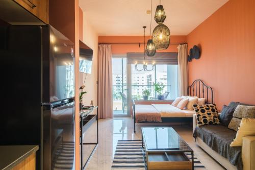 a living room with a couch and a bed at Poolside Charm in Abu Dhabi
