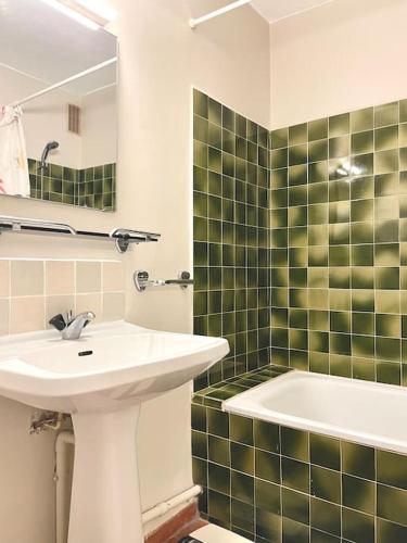 une salle de bain avec un lavabo et une baignoire dans l'établissement 4 personnes-clim-piscine-parking, à Fitou