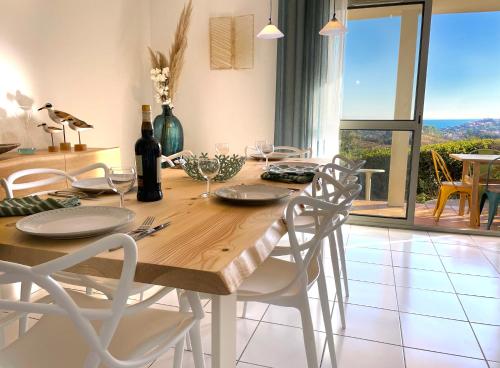 une salle à manger avec une table et des chaises et une vue dans l'établissement Charmant T4, au calme, vue mer, parking, à Collioure