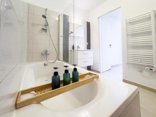 une salle de bain avec une baignoire avec trois bouteilles dessus dans l'établissement Ste Marguerite élégant T2 avec terrasse, à Marseille