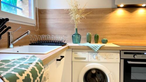 a kitchen with a sink and a washing machine at Les Vigies-T4 au calme-vue mer-terrasse-Parking in Collioure