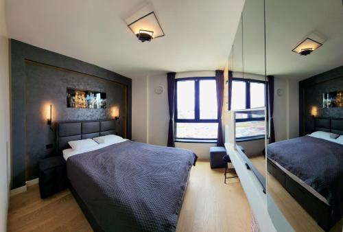 een slaapkamer met 2 bedden en een spiegel bij Belgrade Waterfront 10th fl Lux Apt. w/ City view in Belgrado
