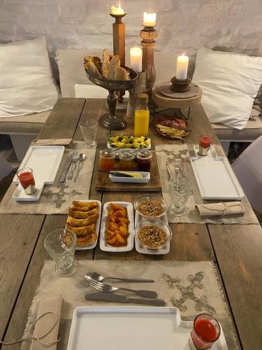a table with plates of food and candles on it at La maison sur la place in Penne-dʼAgenais