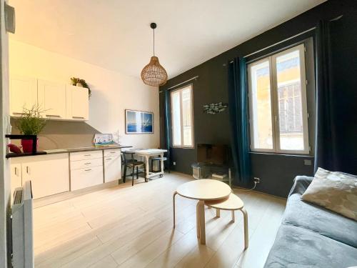 un salon avec un canapé et une table dans l'établissement Agréable T2 avec baignoire, à La Ciotat