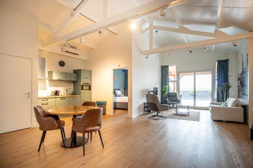ein großes Wohnzimmer mit einem Tisch und Stühlen in der Unterkunft Residentie Oosterschelde in Sint Philipsland
