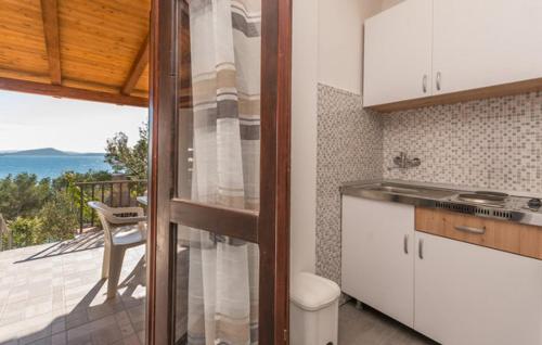 a kitchen with a balcony with a view of the ocean at Apartmani Vanja in Drage