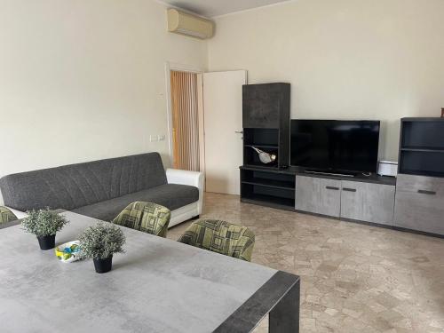ein Wohnzimmer mit einem Sofa und einem Flachbild-TV in der Unterkunft Alba Apartment - Only Family in Riccione