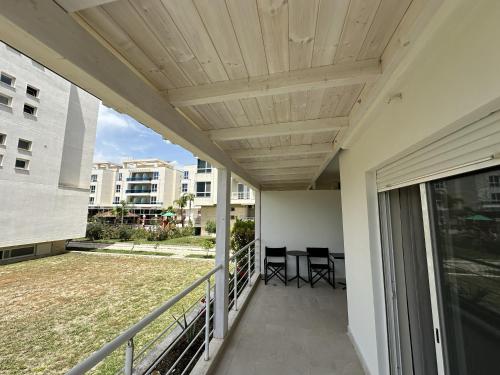 a balcony with chairs and a wooden ceiling at Neti Apartments in Vlorë