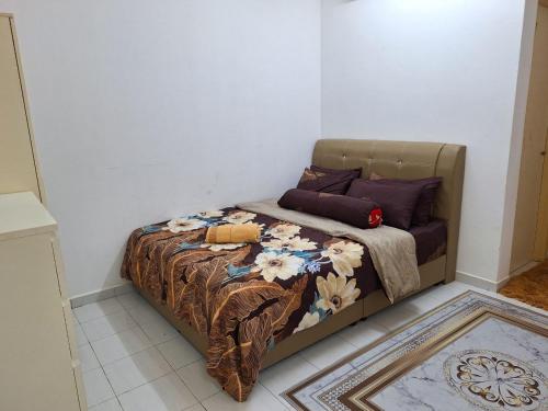 a small bed in a room with a bedspread and pillows at IBRAHIM’S HOMESTAY in Kuala Kerai