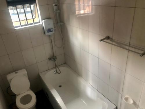 a small bathroom with a toilet and a bath tub at Snug crib in Rubavu