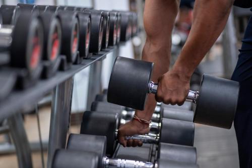 a man holding a dumbbell in a gym at Karachi Marriott Hotel in Karachi