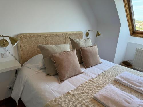 a bedroom with a bed with pillows and a window at O Faiado Da Ria By Oktheway in Culleredo
