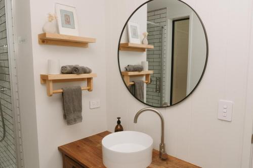 ein Bad mit einem Waschbecken und einem Spiegel in der Unterkunft Treehouse Hideaway in Opua