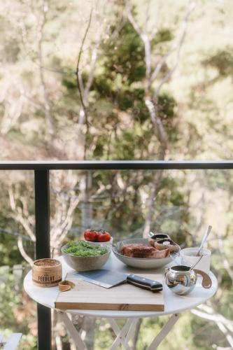a table with two bowls of food on a window at Treehouse Hideaway at Rekindle Treehouses in Opua