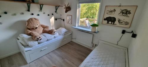 twee teddyberen op een bed in een kamer bij Svensk skovhytte 