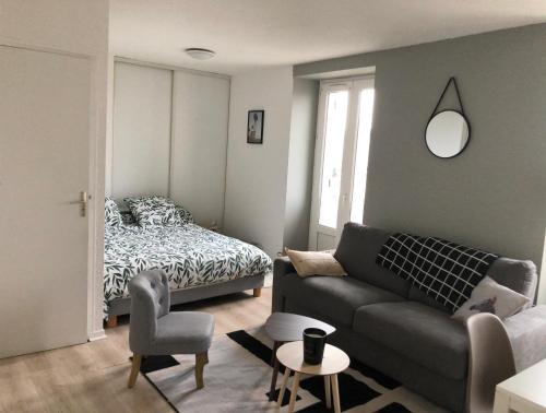 un salon avec un canapé et un lit dans l'établissement Appartement proche des plages, à Trébeurden