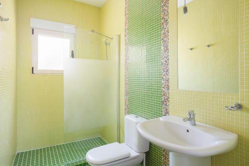 un baño con inodoro y lavabo en Villa Rosa 2, en Oliva