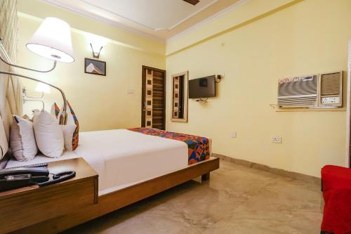 um quarto de hotel com uma cama e um candeeiro em FabHotel Magadh Palace em Patna