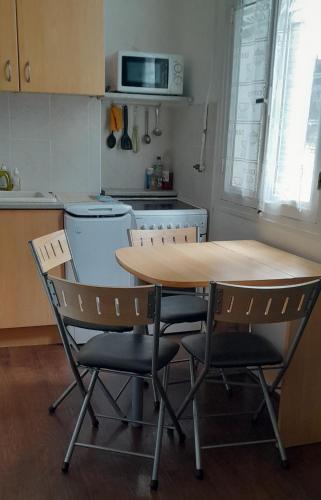 une cuisine avec une table en bois et deux chaises dans l'établissement Les Palmiers NiceAirport, Beach200m, 2bedrooms, Wifi Optic, à Nice