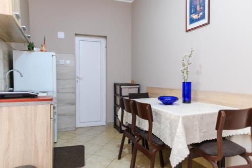 a kitchen with a table with chairs and a refrigerator at Vila Misljenovic, u centru Sokobanje, na pesackoj zoni in Soko Banja