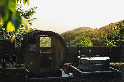 a wooden bath tub sitting next to a wooden bath tub at LUONTE 霧の高原 Glamping in Dōnaru