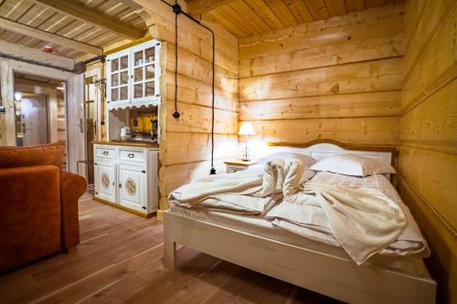 una camera da letto con un letto in una stanza di legno di Salamandra 11 Apartamenty Góralskie w Kościelisku B&B Jacuzzi & Sauna a Kościelisko