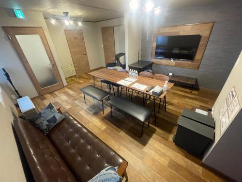 a living room with a couch and a table and a television at Sofil 函館First in Hakodate