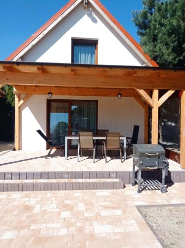 a pavilion with a table and chairs and a grill at Domki u Eweli CAŁOROCZNE ogrzewane kominkiem in Stegna