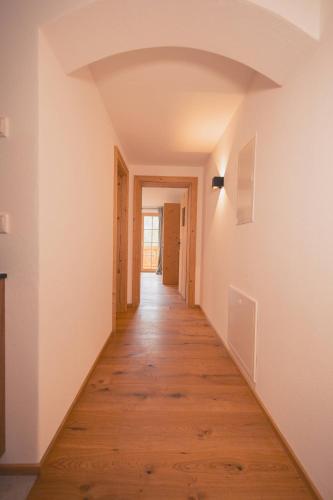 an empty hallway with white walls and wood floors at zumHofer in Gmund am Tegernsee