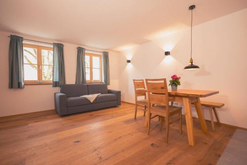 a living room with a table and a couch at zumHofer in Gmund am Tegernsee
