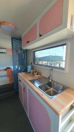 a kitchen with a sink and a window at Countryside, beach view glamping caravan in HaBonim