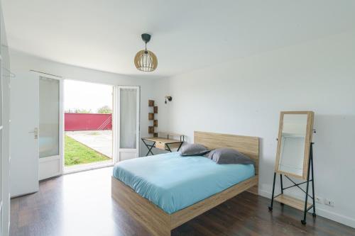 - une chambre avec un lit et un miroir dans l'établissement Le Havre Paisible - Belle maison proche de Paris, à Précy-sur-Marne