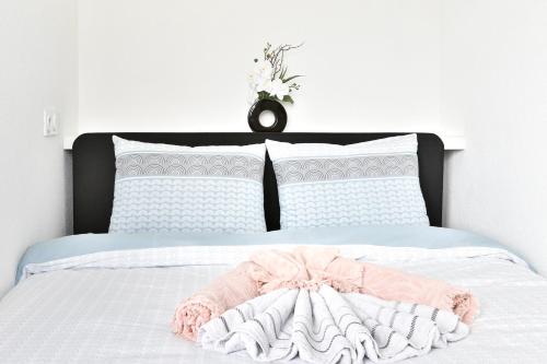 - un lit blanc avec une couverture rose dans l'établissement Studio moderne - 3 Frontières - Aéroport de Bâle - Parking, à Saint-Louis