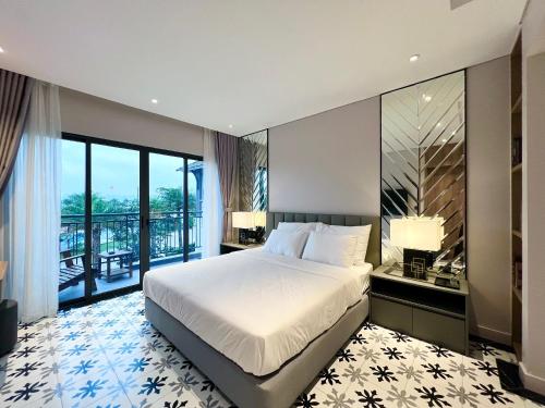 a bedroom with a large bed and a balcony at 3BR Sonasea Villa - Casa Retreat Van Don in Cái Rồng