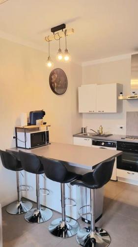 une cuisine avec une table avec des chaises et un micro-ondes dans l'établissement Superbe T2 cosy plein centre, à Narbonne
