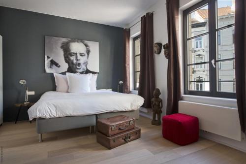 ein Schlafzimmer mit einem Bett mit einem Bild eines Mannes in der Unterkunft Smartflats Premium - Palace du Grand Sablon in Brüssel